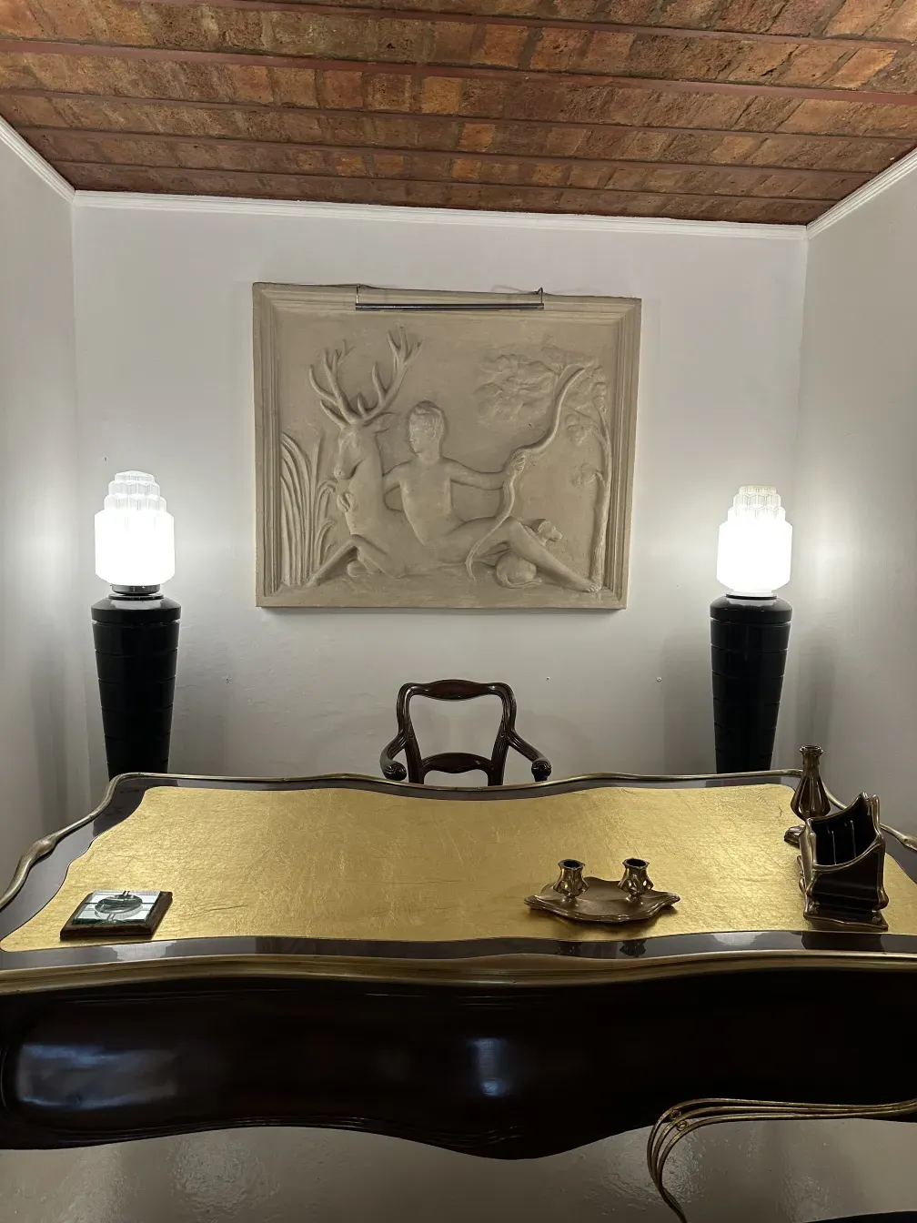 escritorio antigo com superfície dourada e itens decorativos