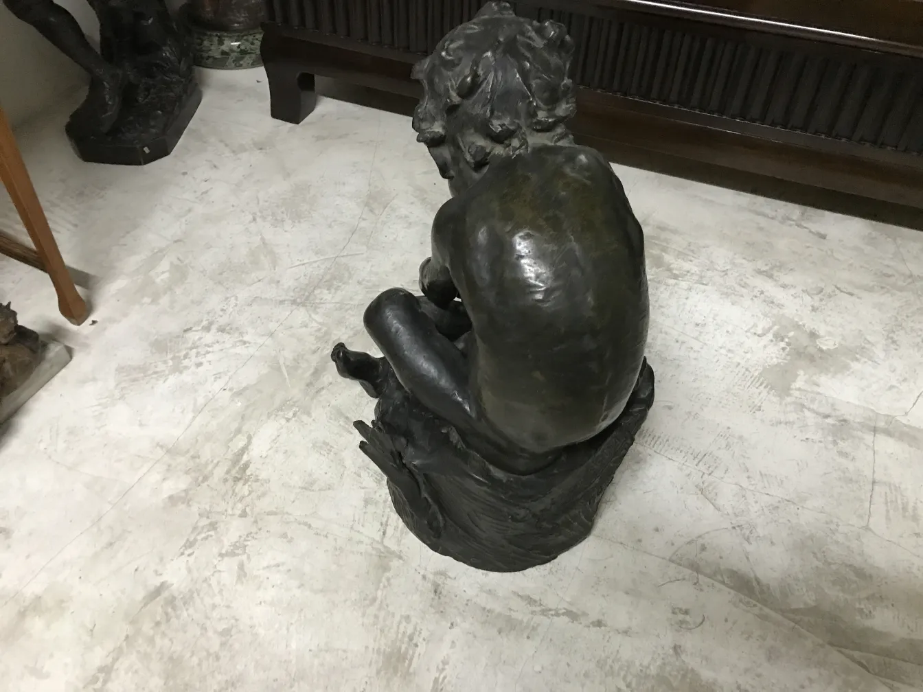 escultura antiga de uma figura humana em posição sentada