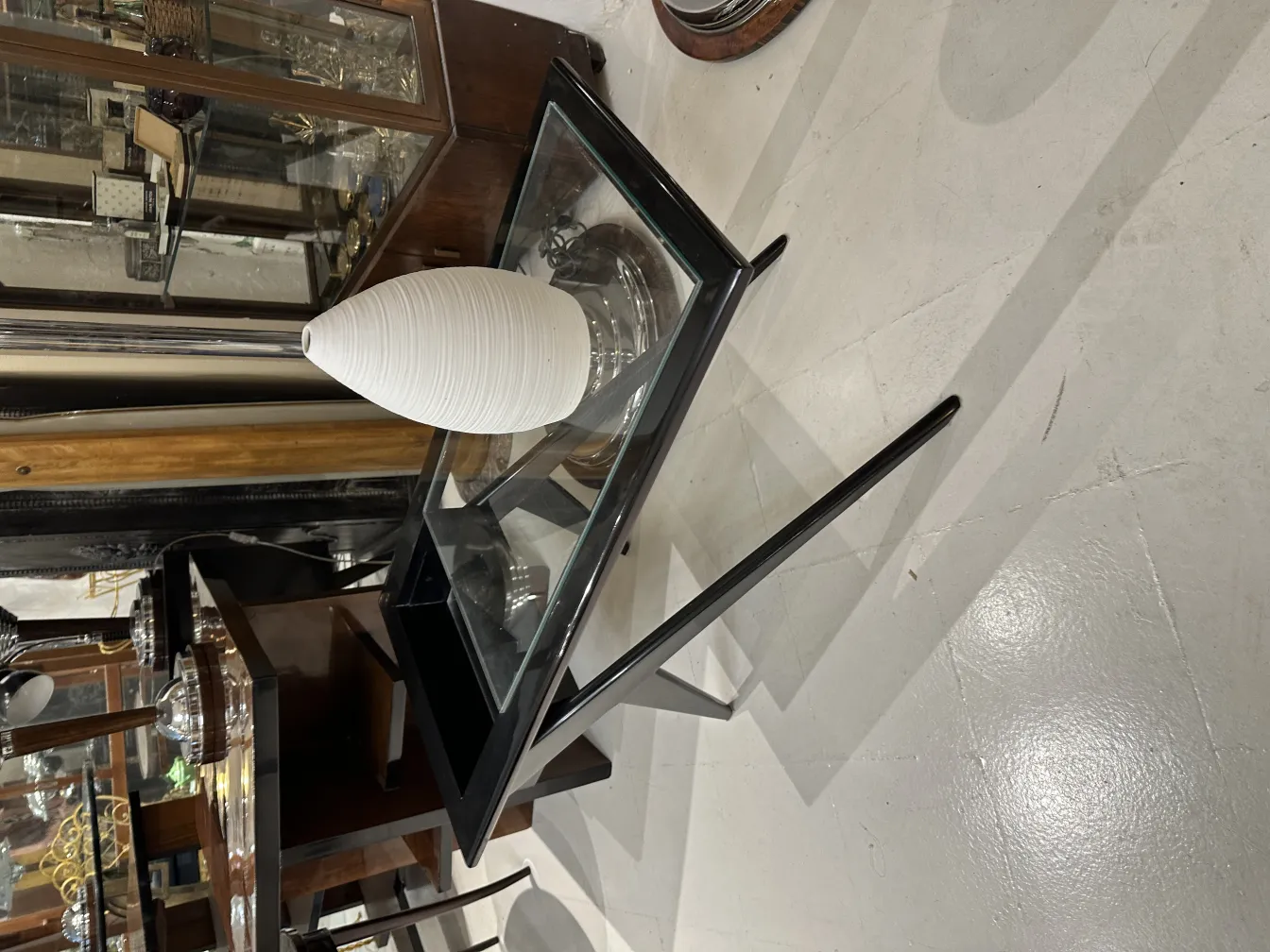 古董白色陶瓷花瓶在玻璃桌上。