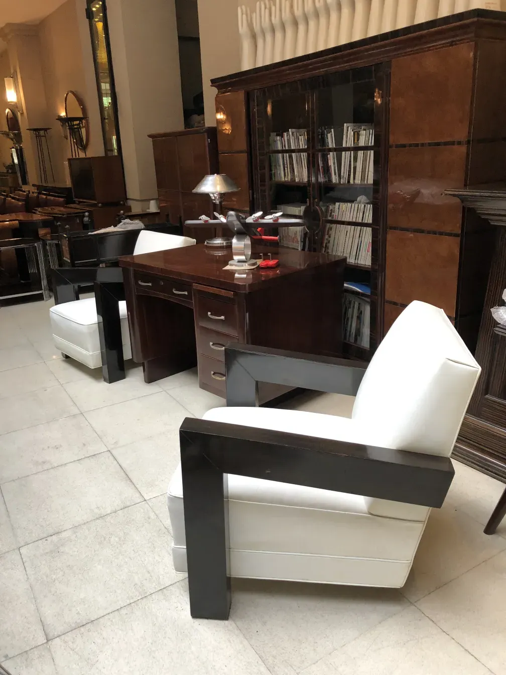 Vista de un antiguo escritorio de oficina en un ambiente elegante con una silla blanca.