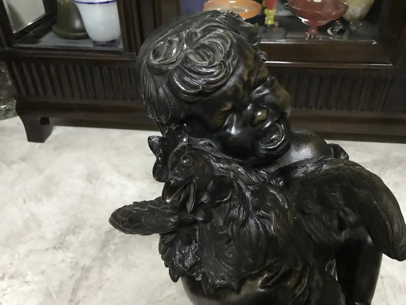 Antike Skulptur, die eine Kinderfigur mit einem Vogel darstellt.