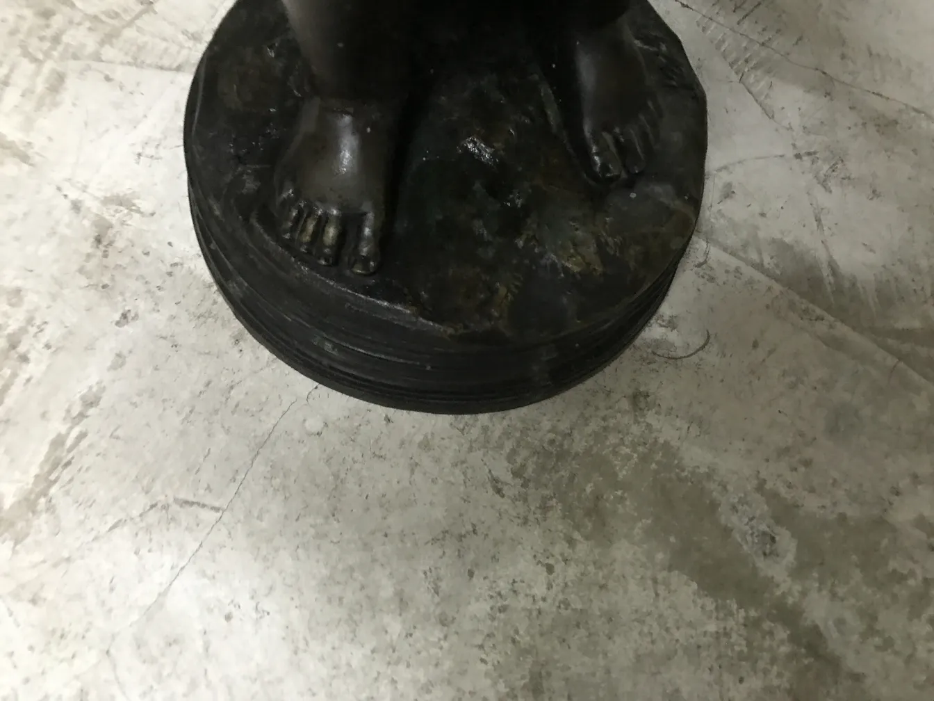 scultura antica con piede su base circolare