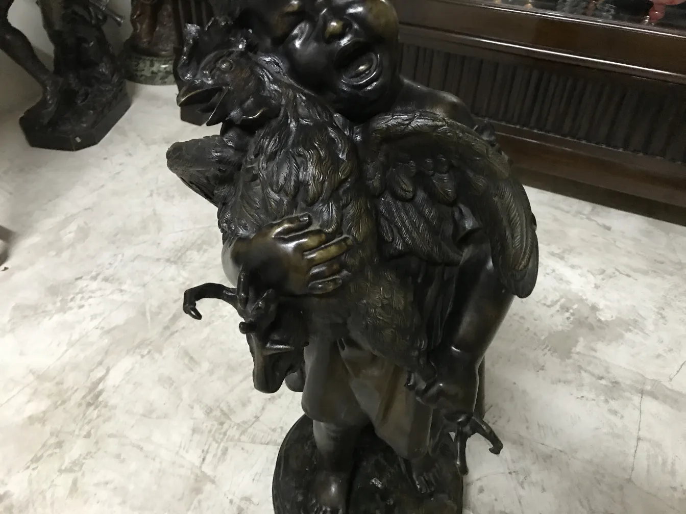 escultura antiga representando uma figura segurando um pássaro