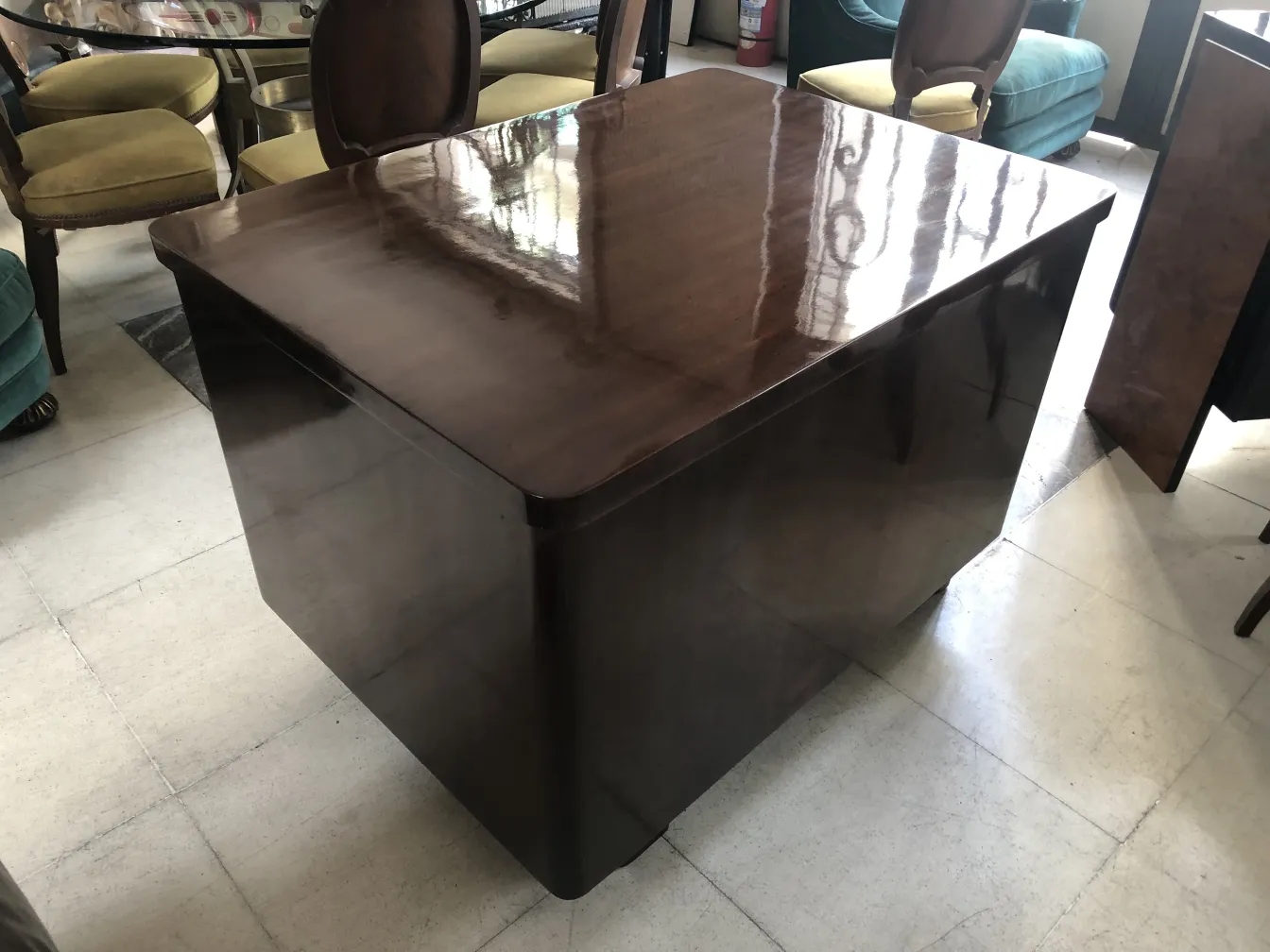 Antiker Schreibtisch in quadratischer Form, mit verschiedenen Stühlen.