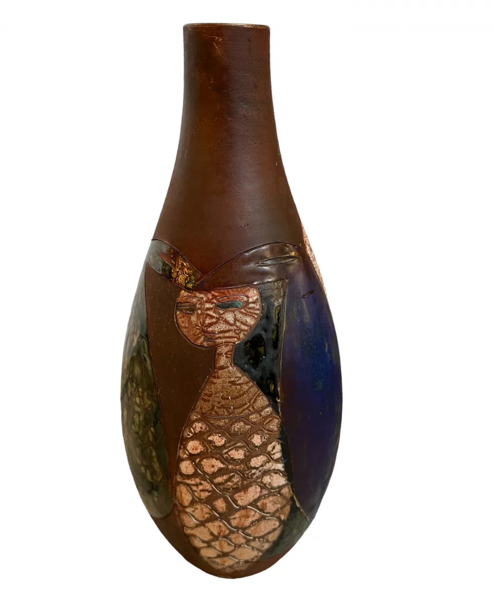 Jarrón antiguo de cerámica con colores y formas únicas, decorado con diseños artísticos.