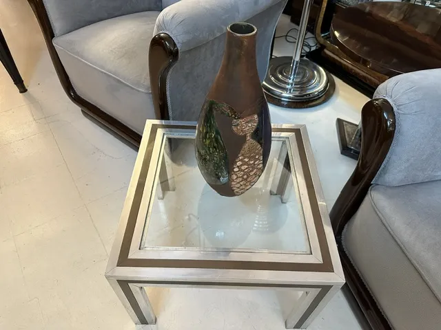 vase en céramique ancienne avec décorations sombres, sur une table moderne