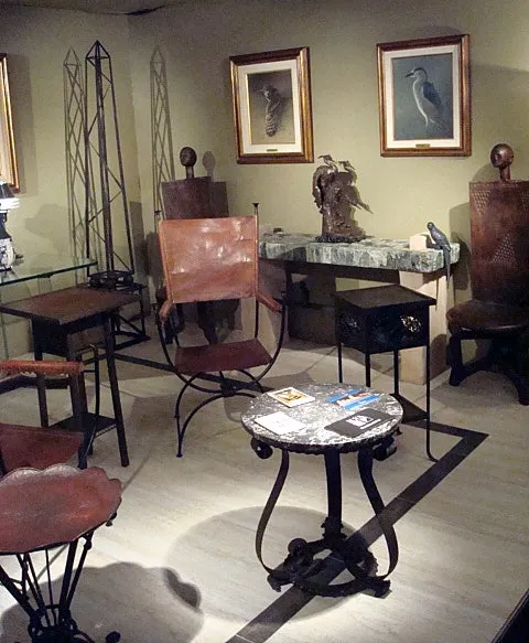 sculpture ancienne dans une pièce avec des meubles et des tableaux