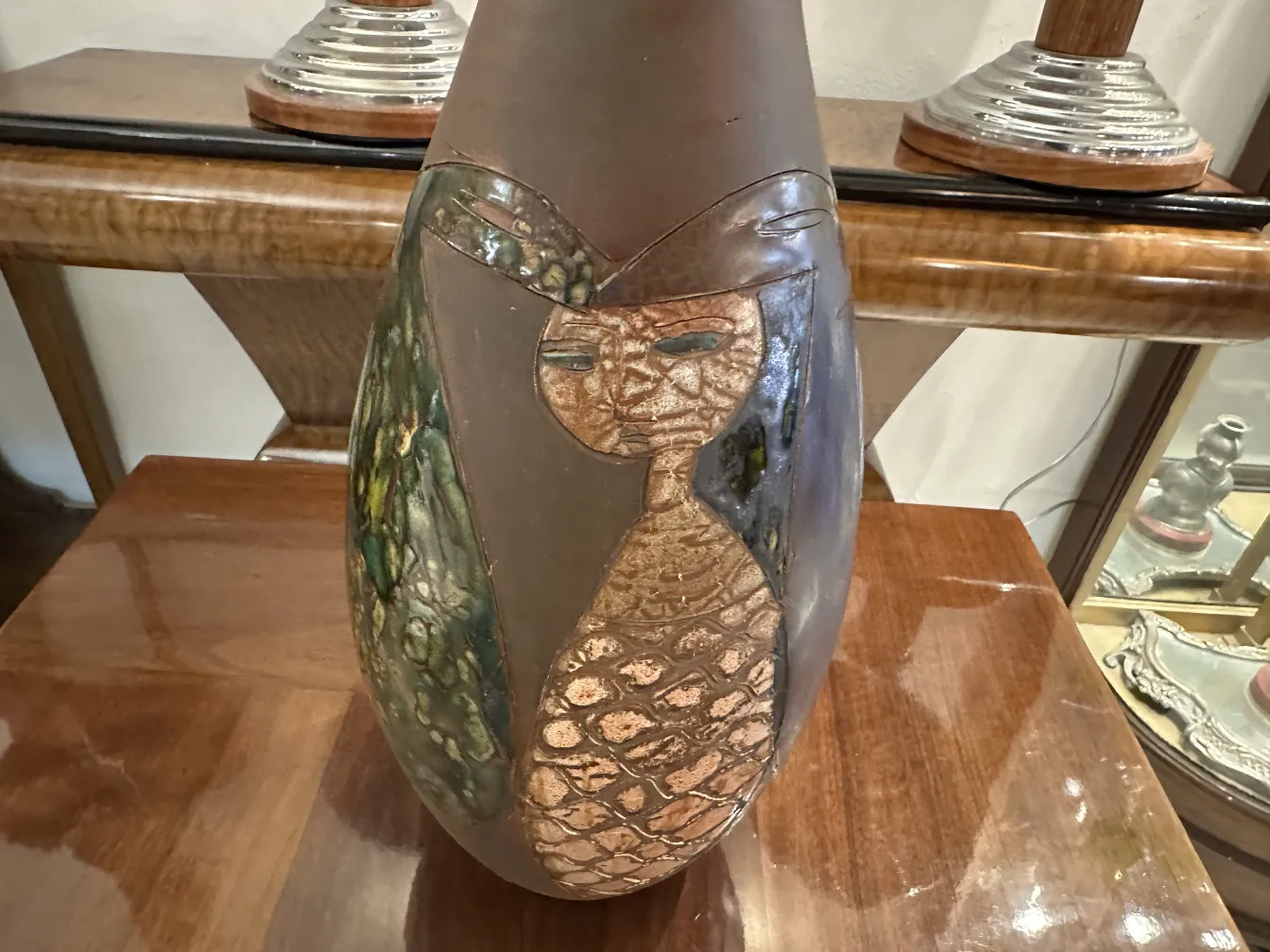Antique ceramic vase with unique patterns, natural colors, in a cozy setting.