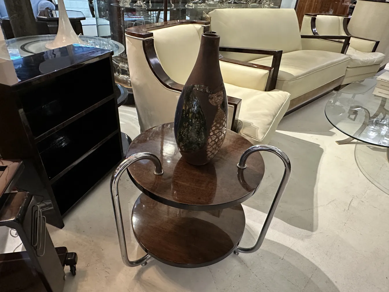 Jarrón de cerámica antigua con diseños ornamentales sobre una mesa moderna.