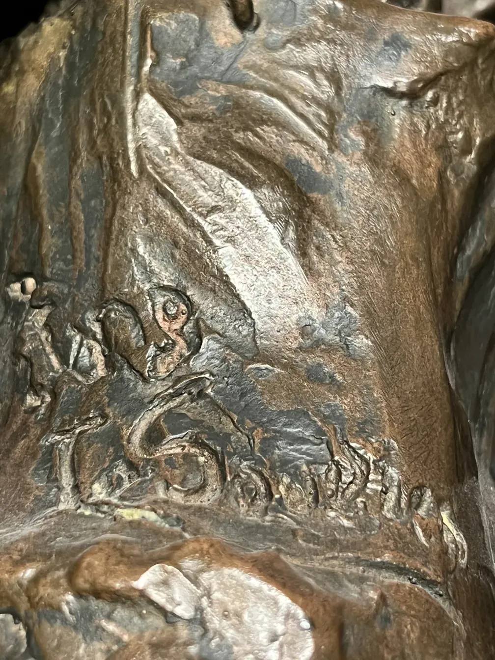 escultura em bronze com detalhes e assinatura, ambiente antigo