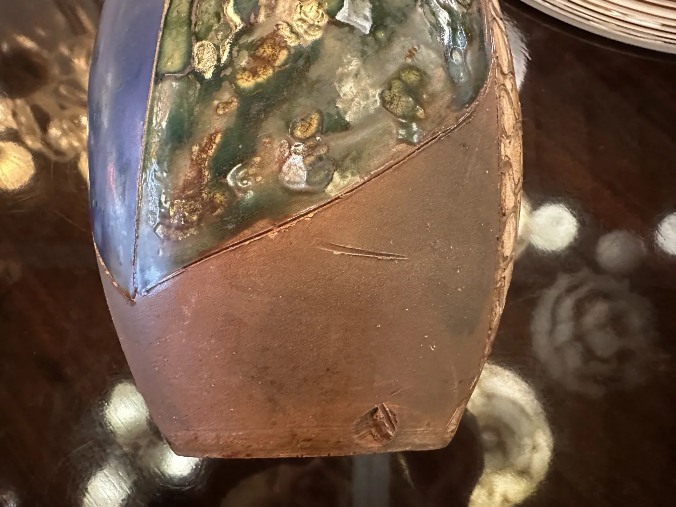 Antica ceramica decorativa a forma ovale con colori vivaci e dettagli sulla superficie.