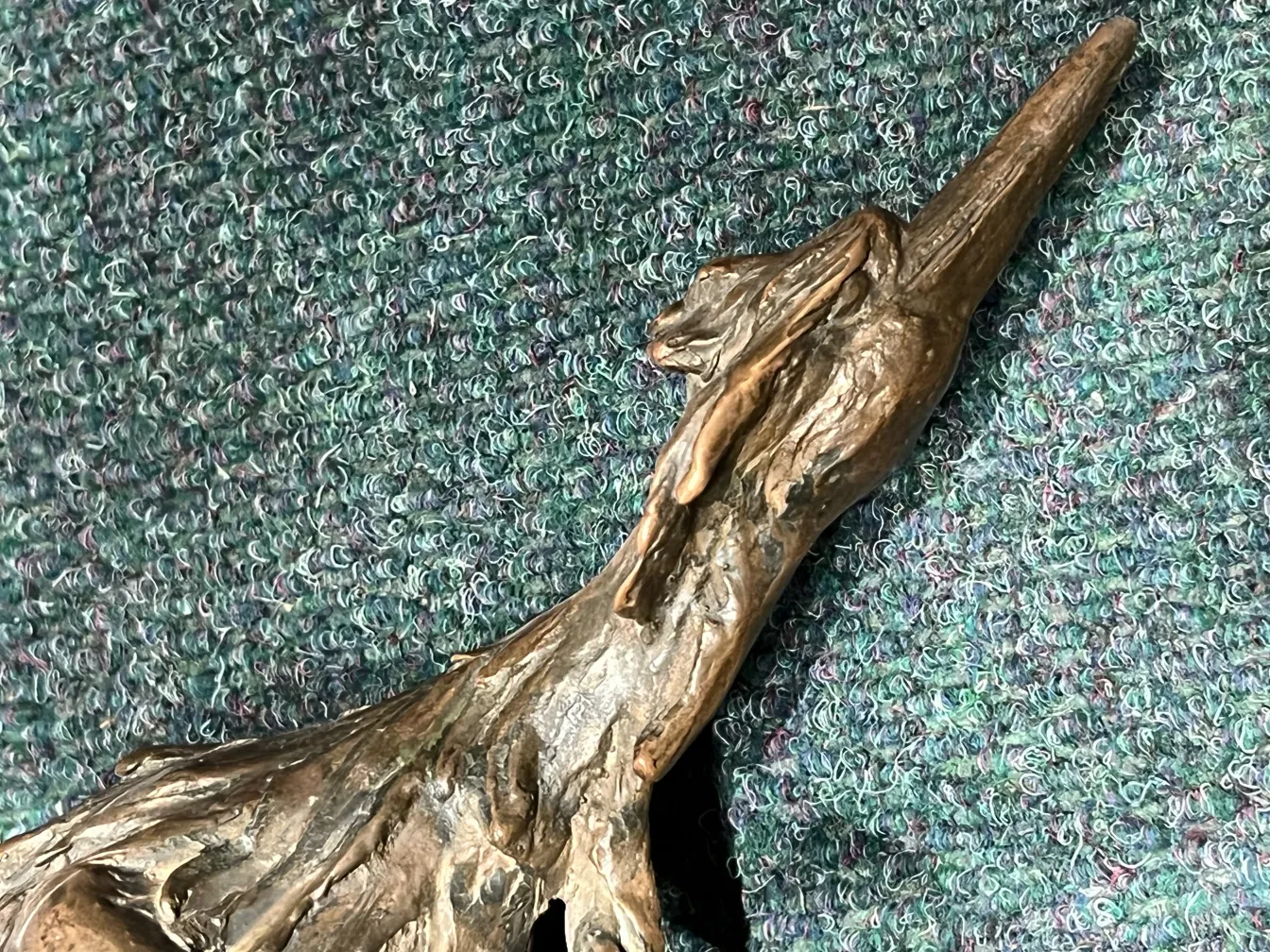 Escultura antiga de uma figura, detalhada e única em forma.