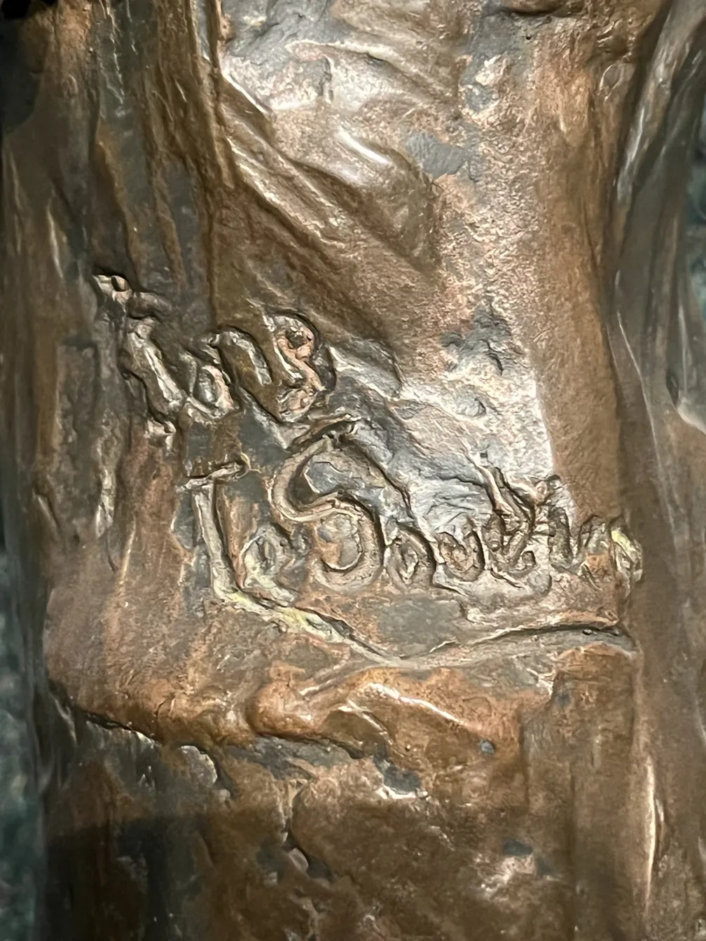 Detalhes de uma escultura antiga com inscrições visíveis