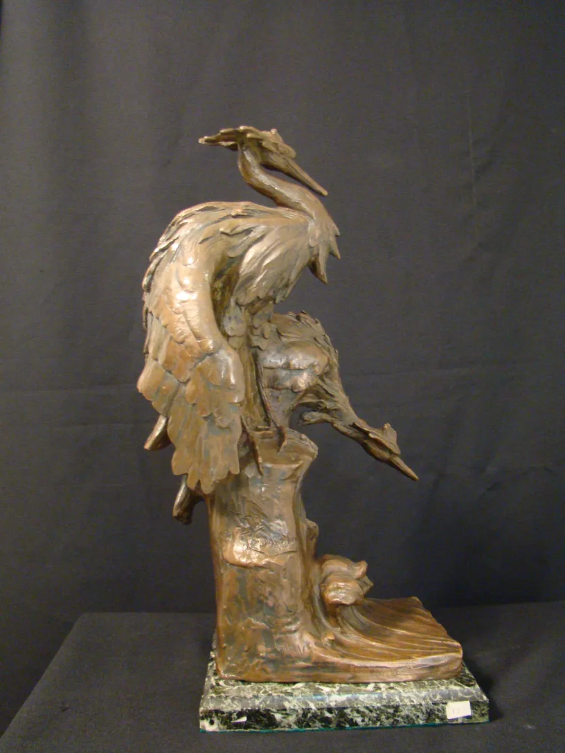 antique sculpture featuring birds in elegant pose, solid base
