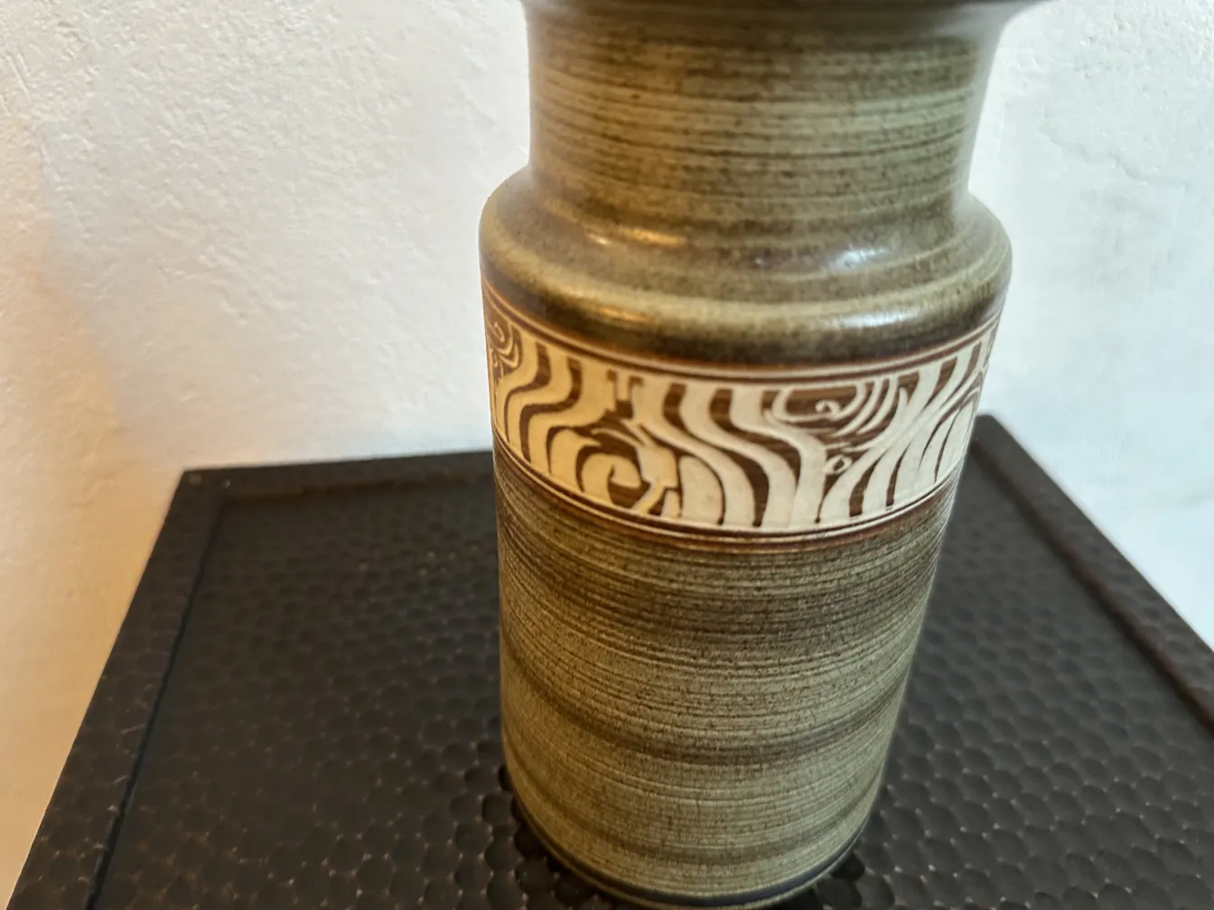 Antique gray ceramic with a raised design in the middle.