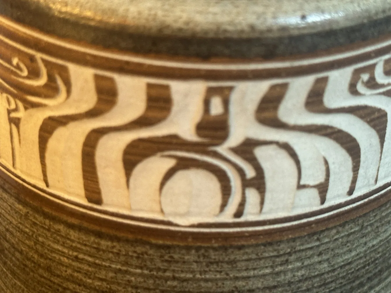 Céramique ancienne avec motifs en marron et crème.