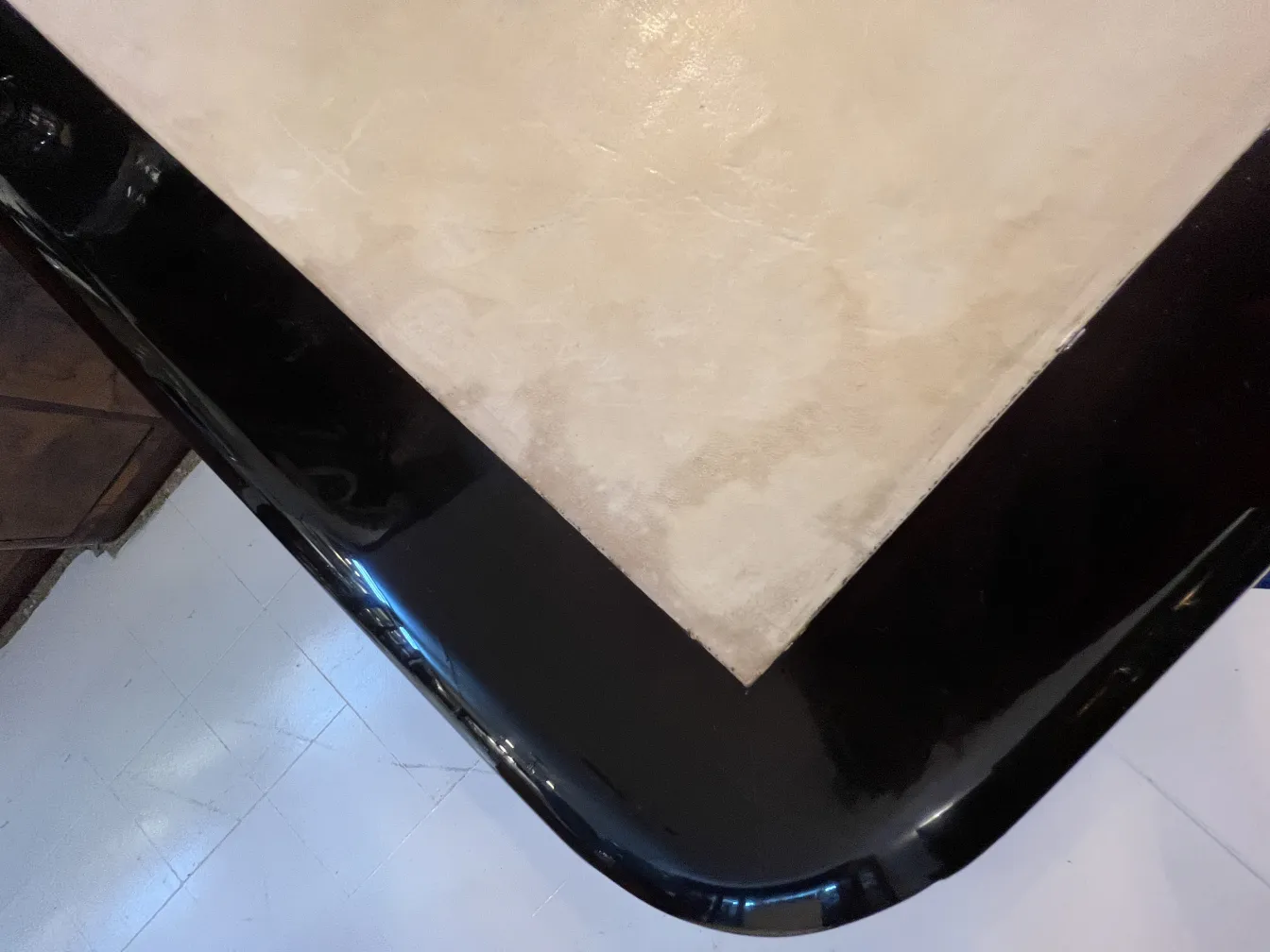 View of an antique black desk with rounded corners.