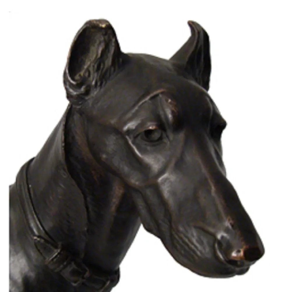 Tête de chien en sculpture antique, détails fins et expression réaliste.