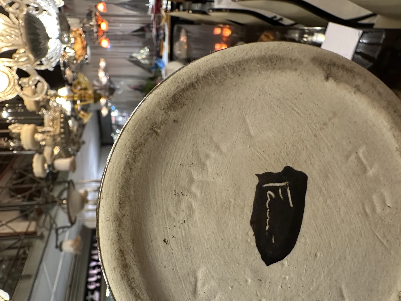 Assiette en céramique ancienne avec décoration subtile et signature