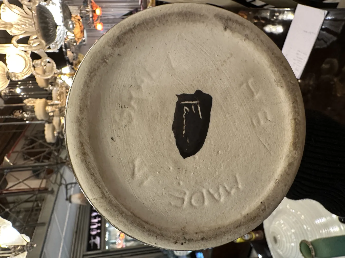 Bottom of decorative antique ceramic, showing visible details and pattern, surrounded by soft lights