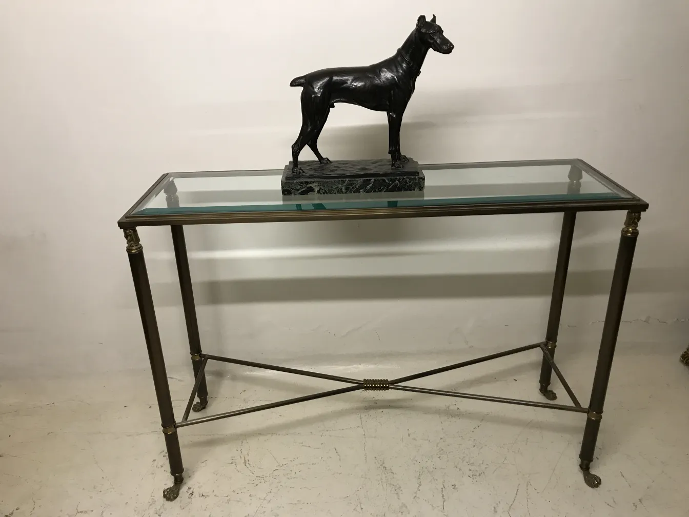 escultura antiga de um cachorro em uma mesa de vidro