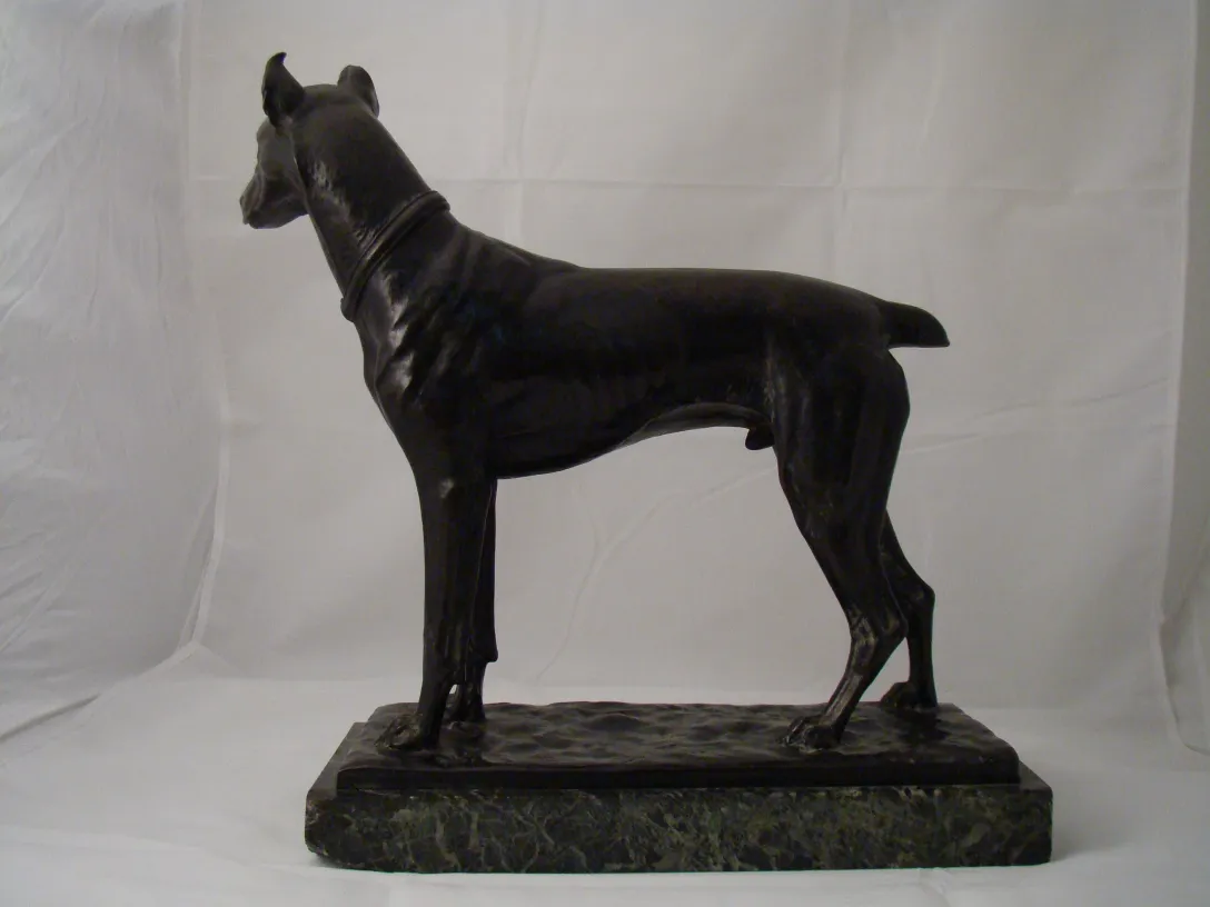 Sculpture ancienne d'un chien dans un style classique, mettant en valeur ses formes.