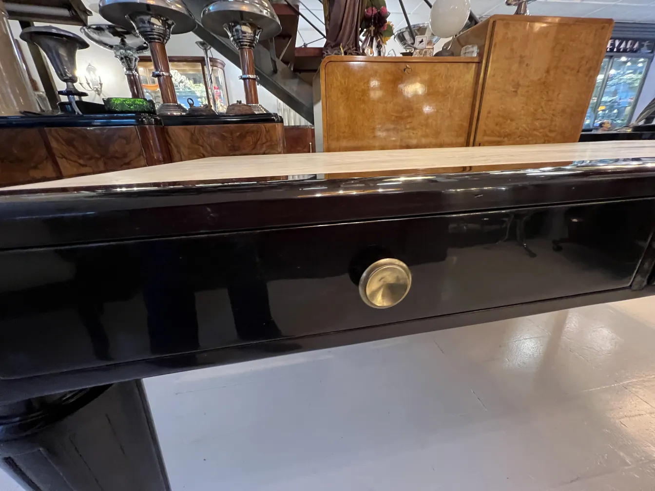 escritorio antiguo negro con un diseño elegante y un cajón dorado