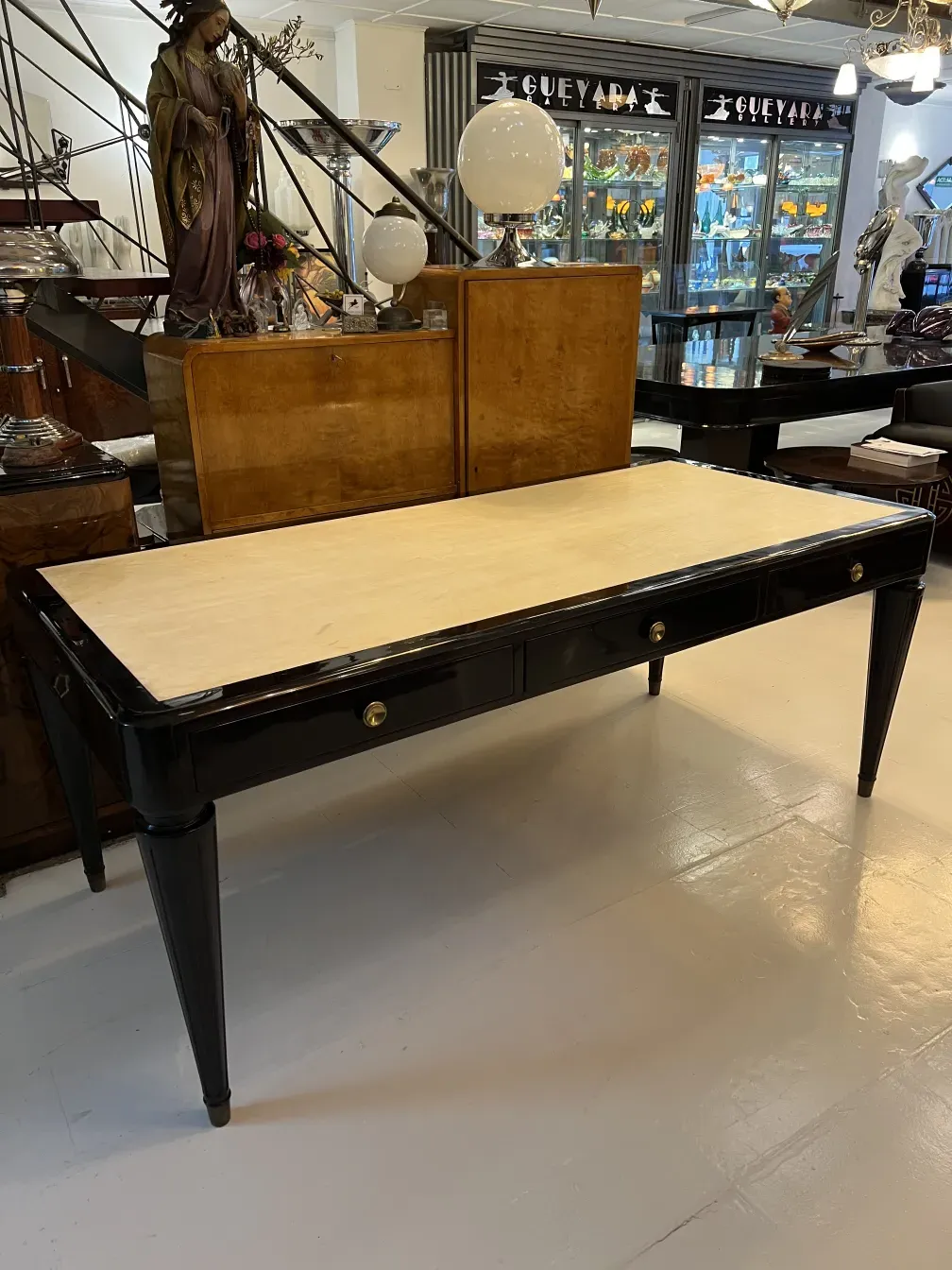 Scrivania antica con superficie chiara e gambe eleganti, in un ambiente elegante.