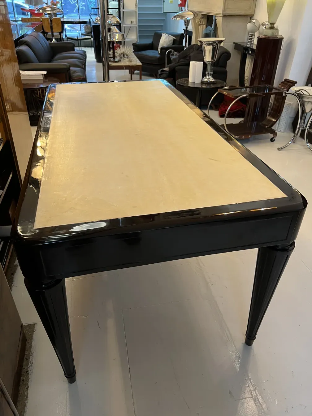 Bureau ancien avec une surface claire et des pieds élégants, dans un cadre convivial.