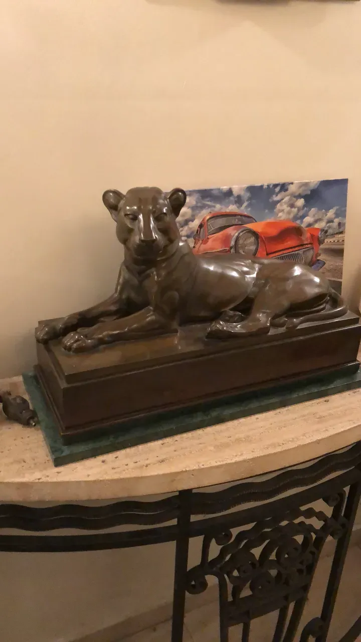 sculpture antique de lion reposant sur un socle