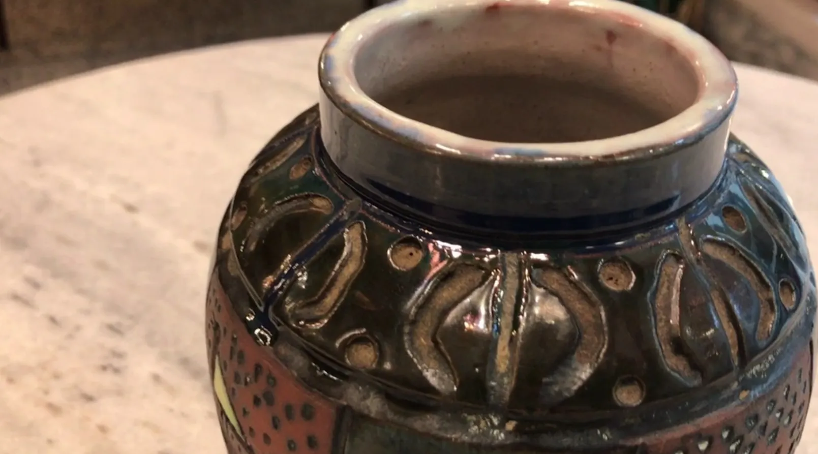 Vaso in ceramica antico con decorazioni colorate e dettagli scolpiti