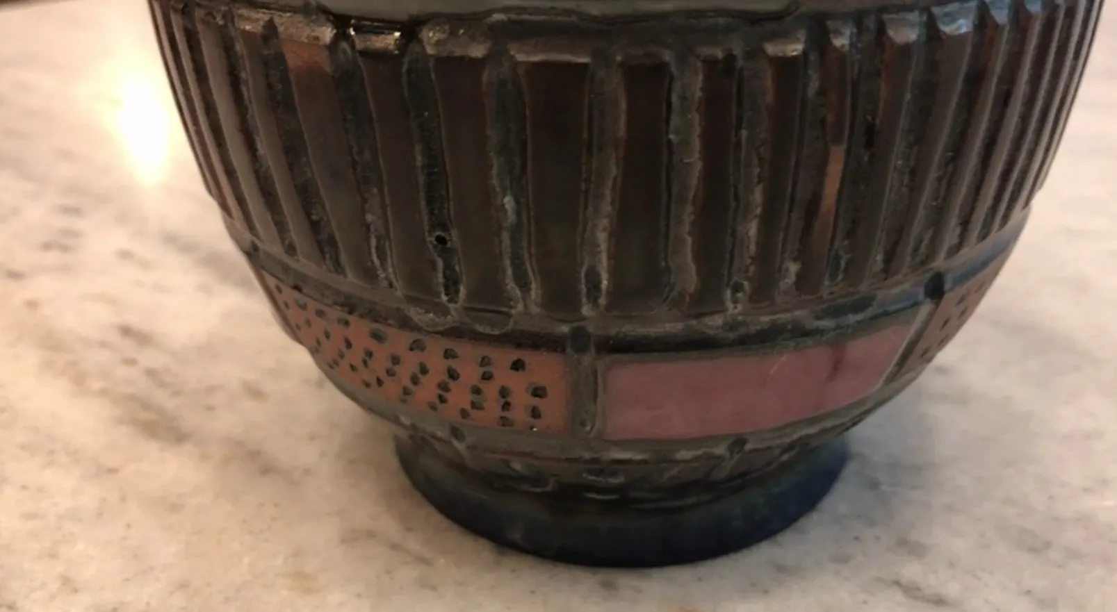 Antiga cerâmica decorada com detalhes únicos e formato distinto.