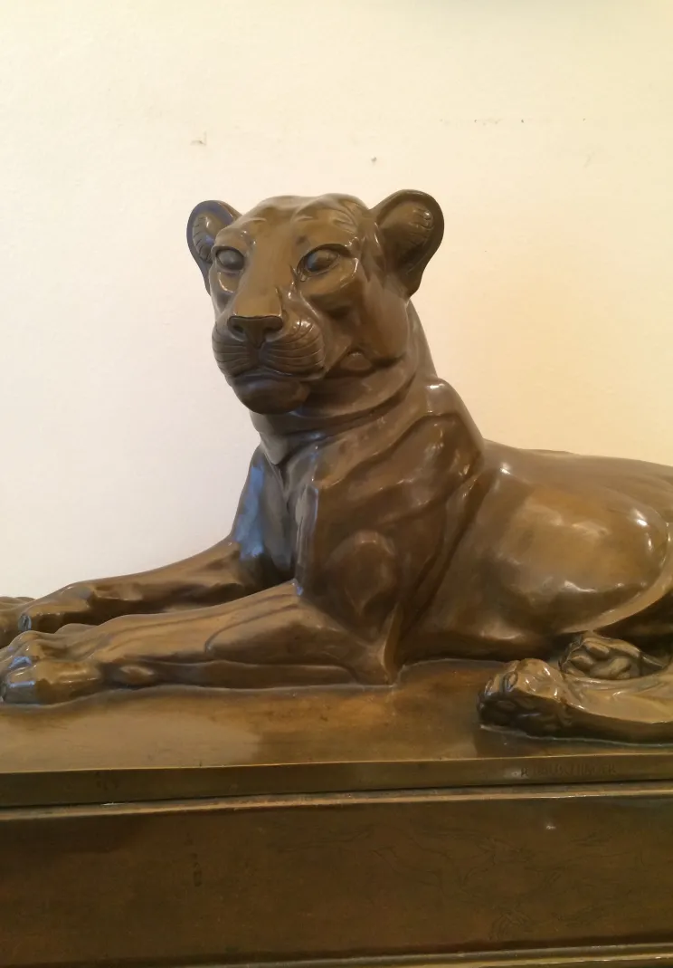 Antike Skulptur einer Löwin in liegender Position, realistisch.