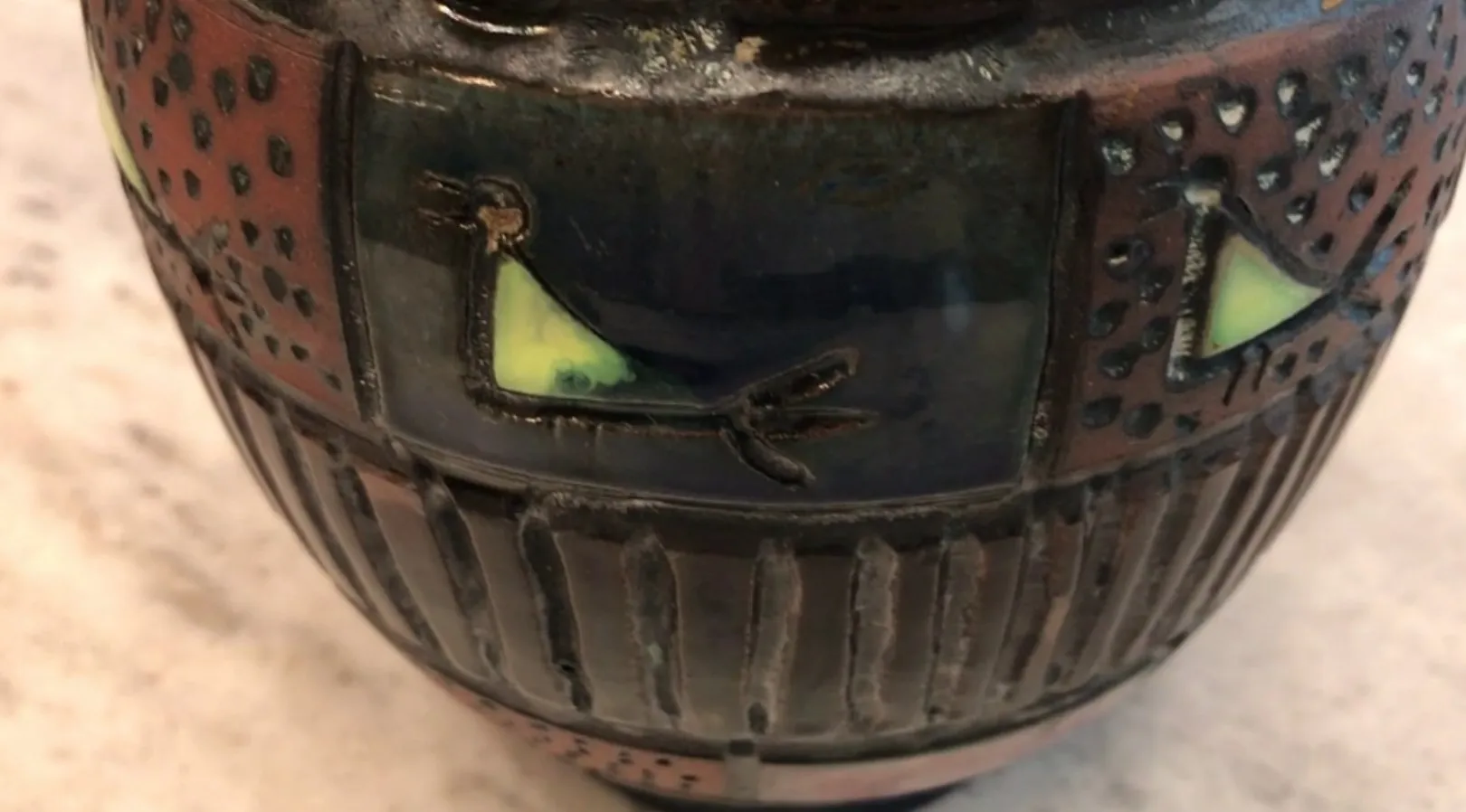 Alte Keramik mit Tierdekoration, farbenfrohen und strukturierten Details.