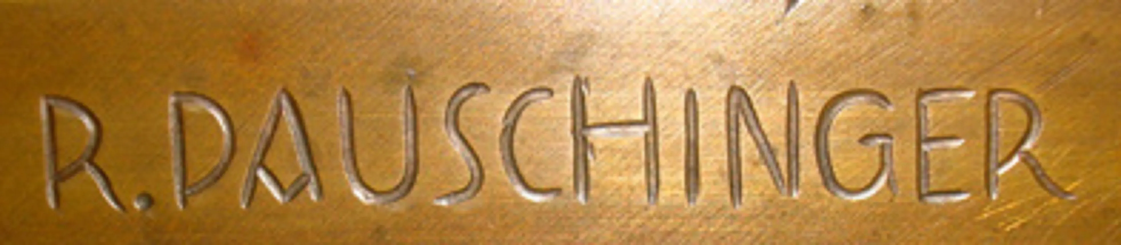 Escultura antigua del artista R. Pauschinger con firma visible.