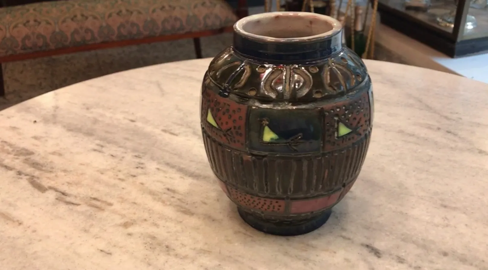Antique ceramic vase featuring bird designs and vibrant colors.
