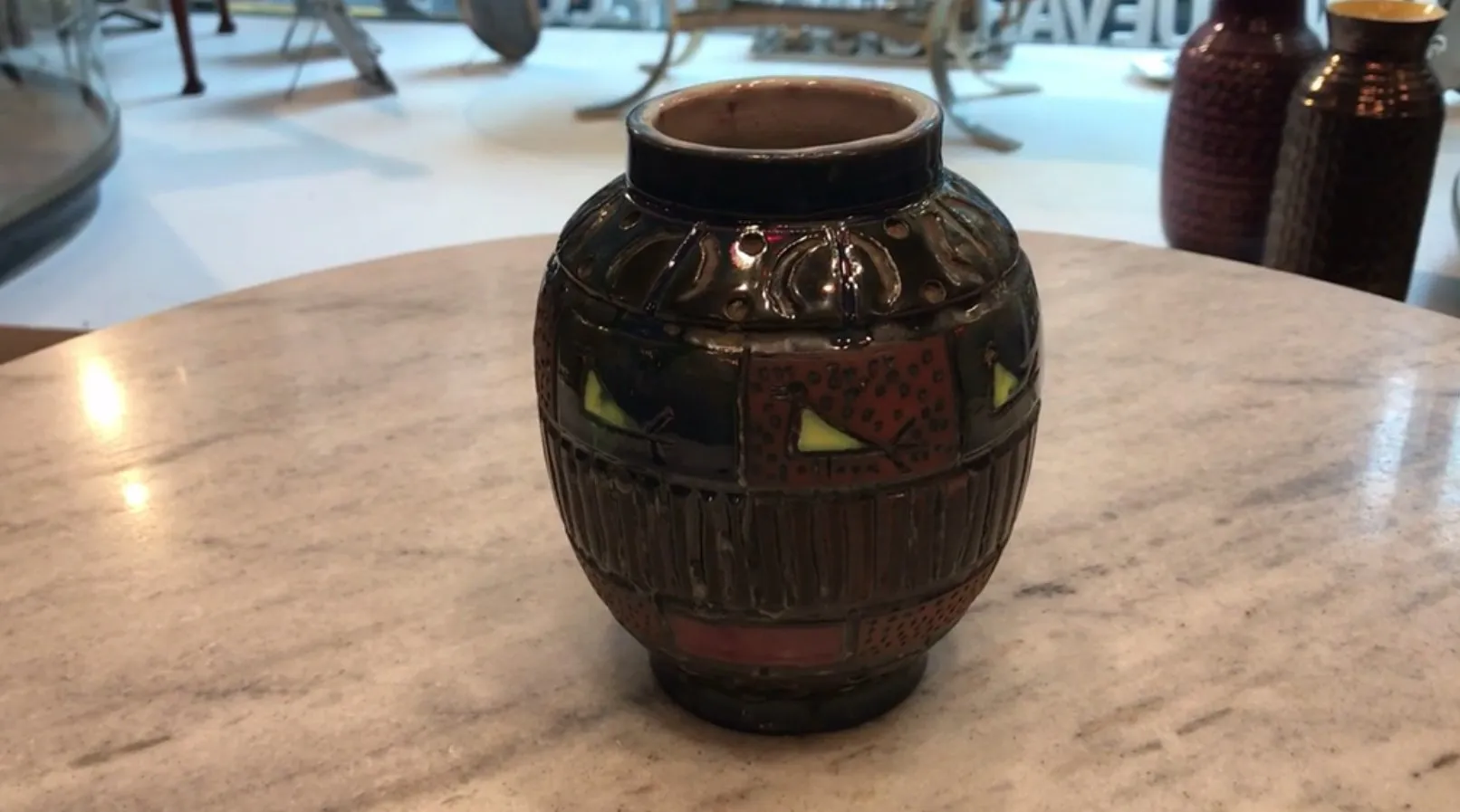 Cerâmica decorativa antiga em tons escuros e cores vibrantes, com designs únicos.