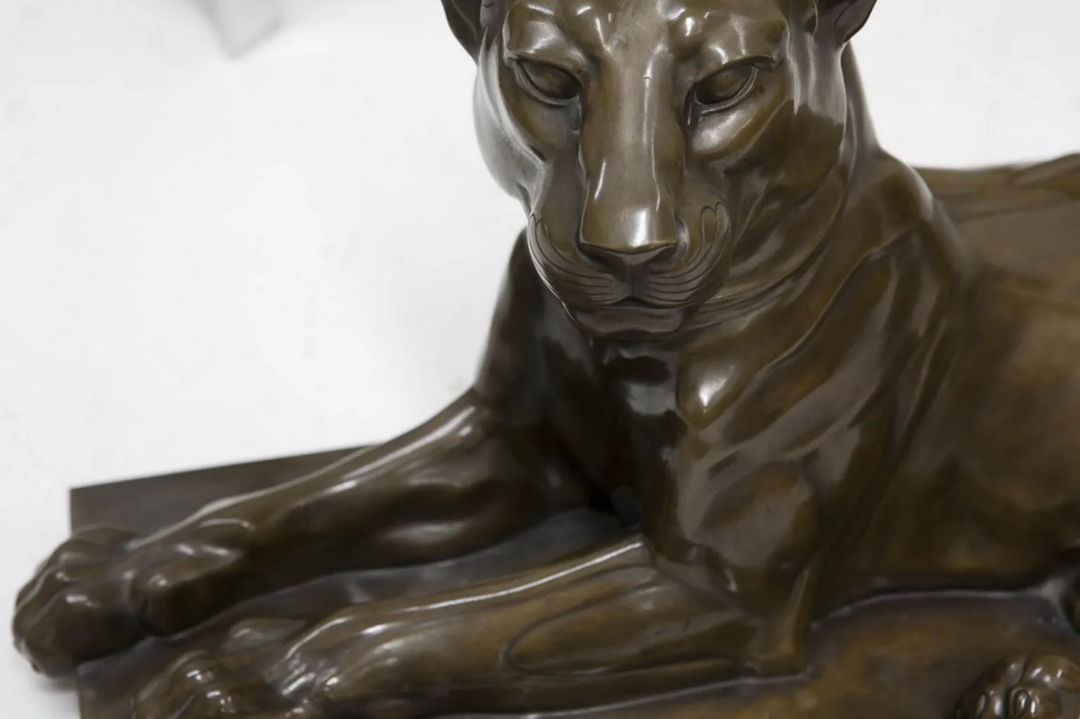 antique sculpture of a lion in a relaxed position