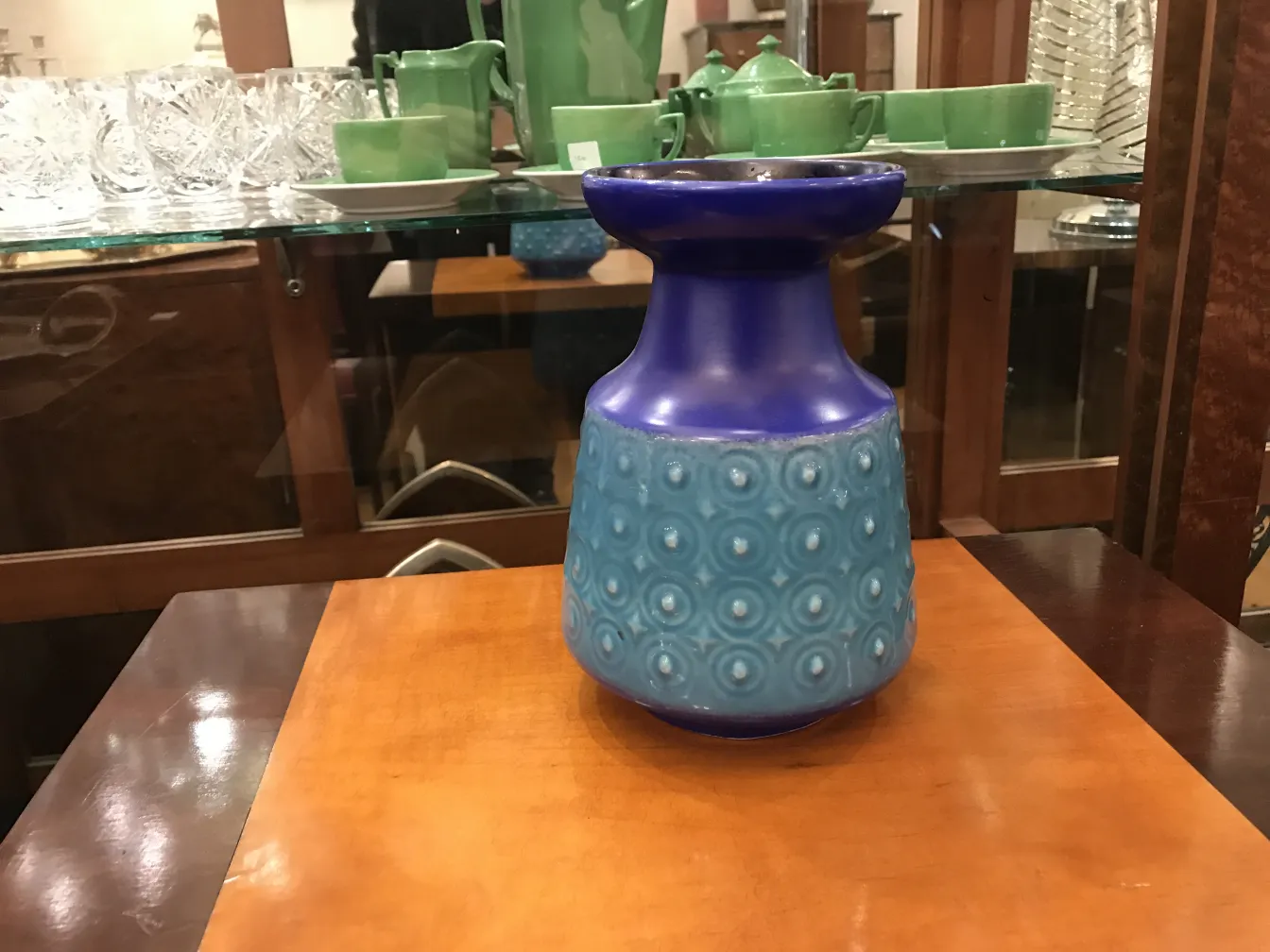 Jarrón de cerámica antigua con diseño azul claro y oscuro, fondo elegante.