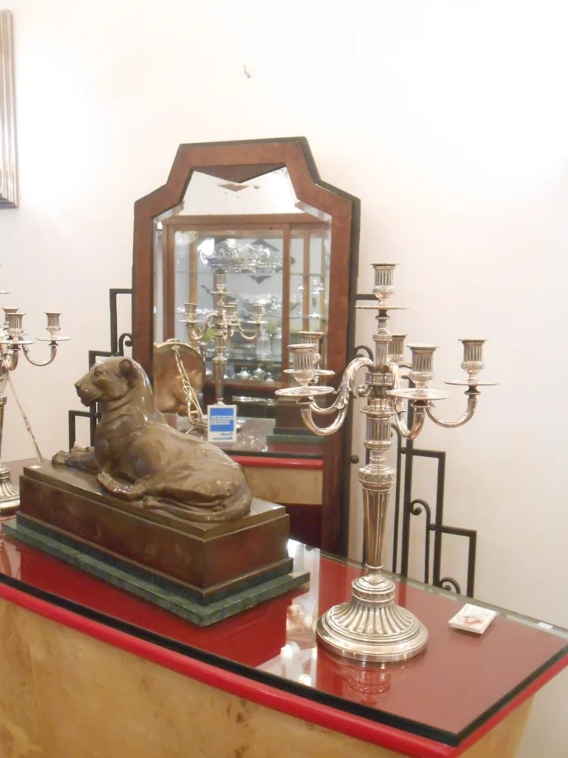 escultura antiga com base, cachorro deitado, ambiente elegante