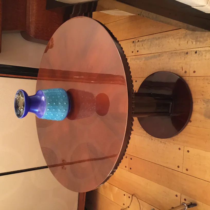 Vaso in ceramica blu su un tavolo rotondo in legno, ambiente elegante