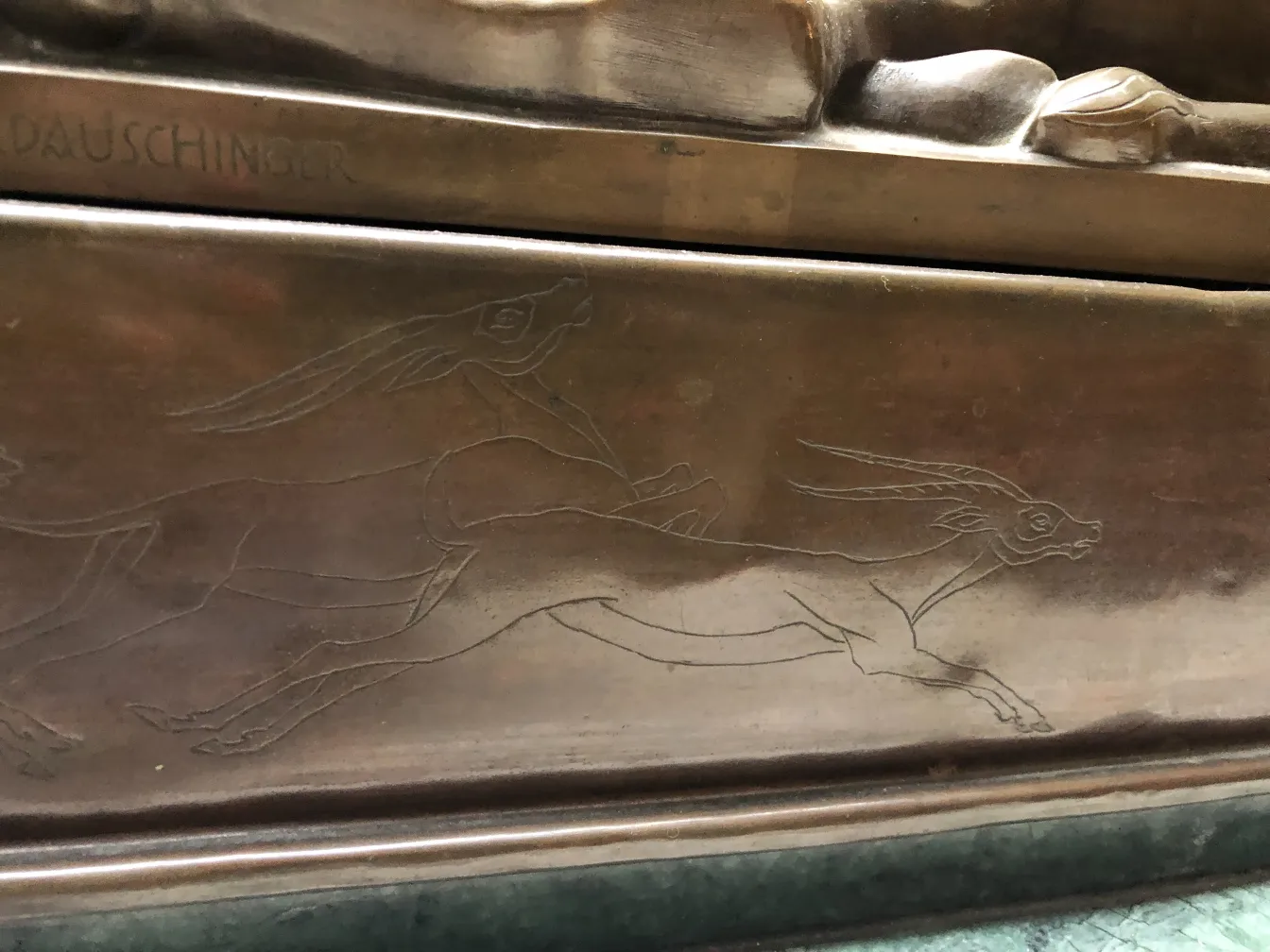 sculpture antique avec des gravures d'animaux courant sur la base
