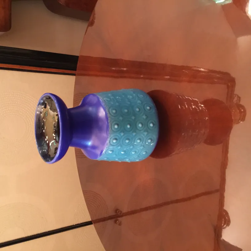 Vaso azul antigo de cerâmica com desenho texturizado na parte inferior.