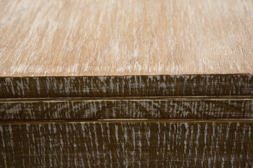 Primo piano di una scrivania antica con superficie texturizzata in tonalità chiare