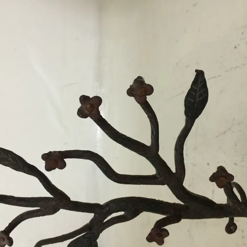 Ancient sculpture resembling a branch with flowers and leaves.