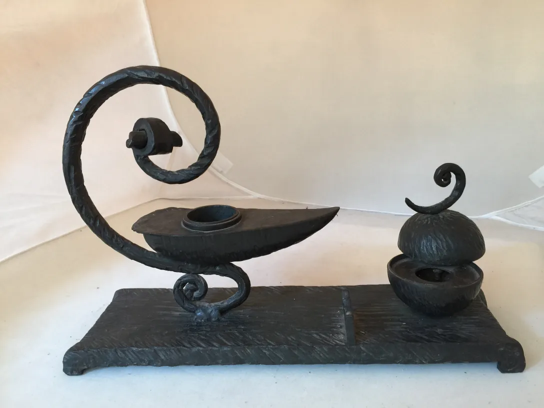 scultura antica con forme curve e dettagli decorativi in un ambiente neutro