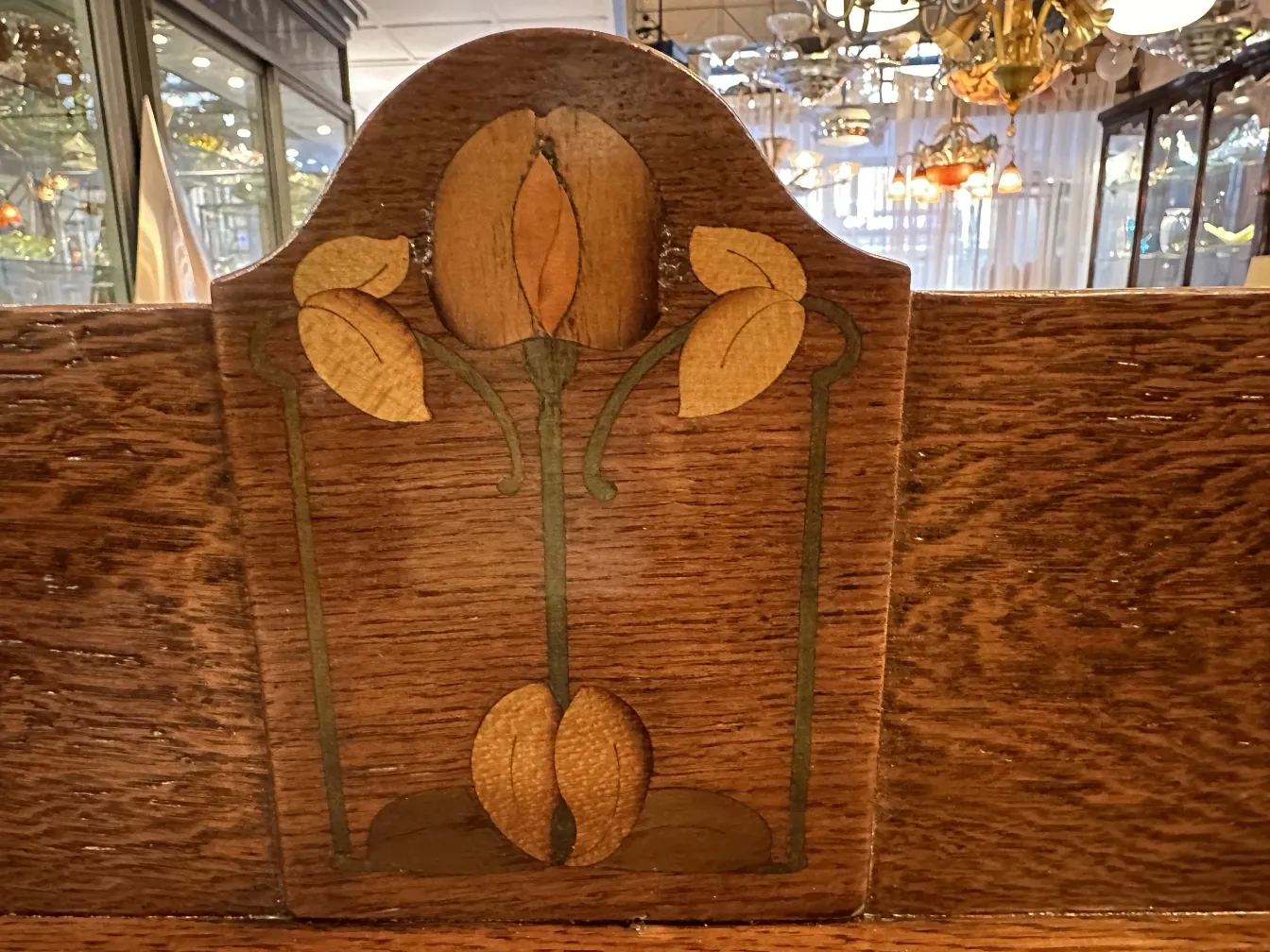 Bureau ancien avec motif floral en haut, arrière-plan avec d'autres antiquités.