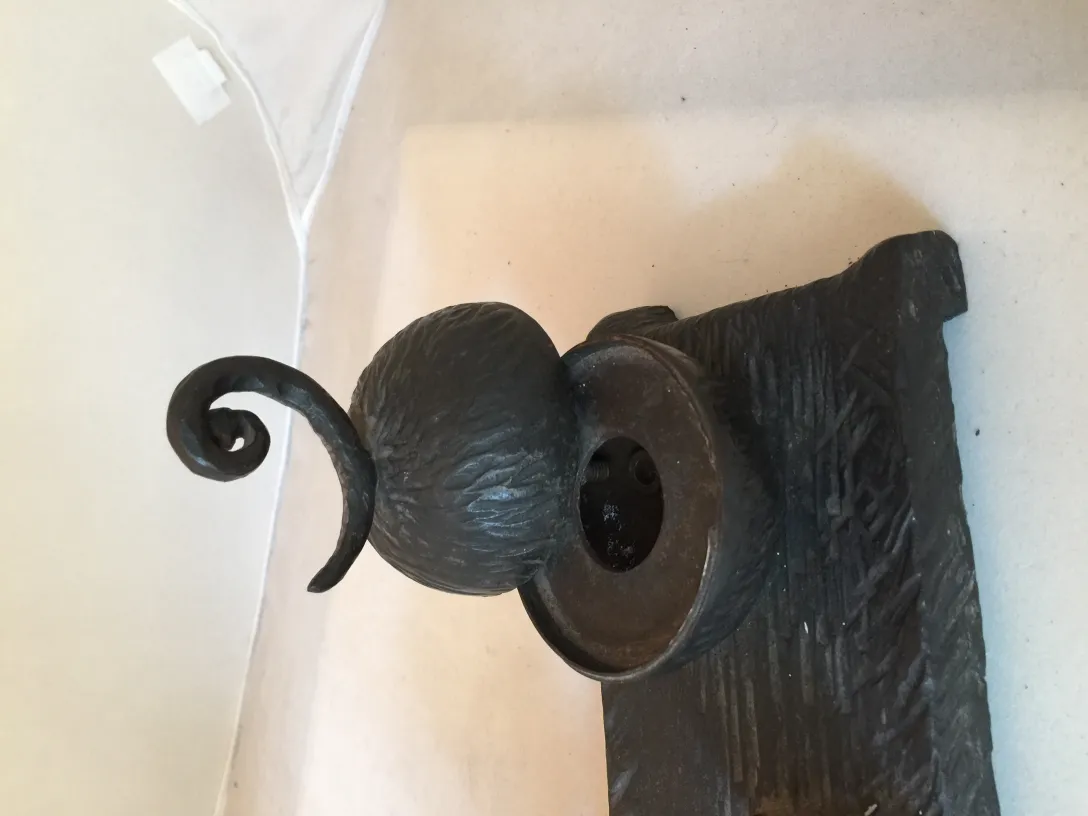 sculpture ancienne avec formes arrondies et base décorative sur fond clair