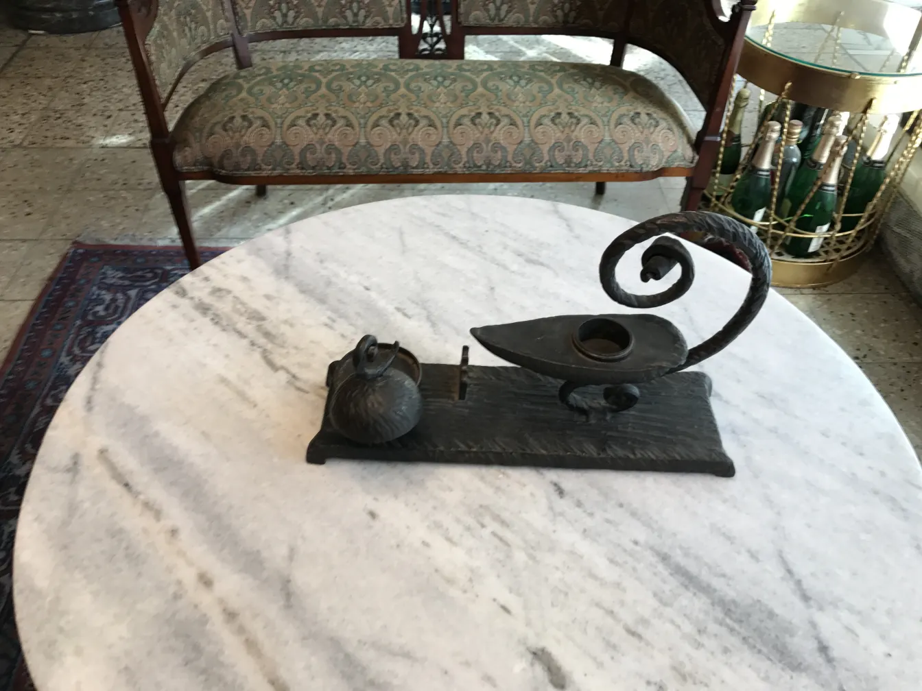 une sculpture ancienne en forme de lampe avec une cruche