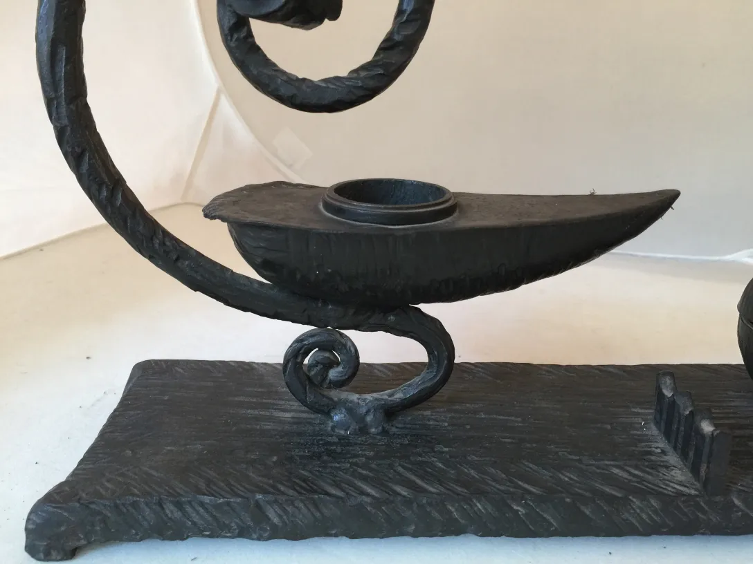 Escultura antigua en forma de lámpara decorativa negra.